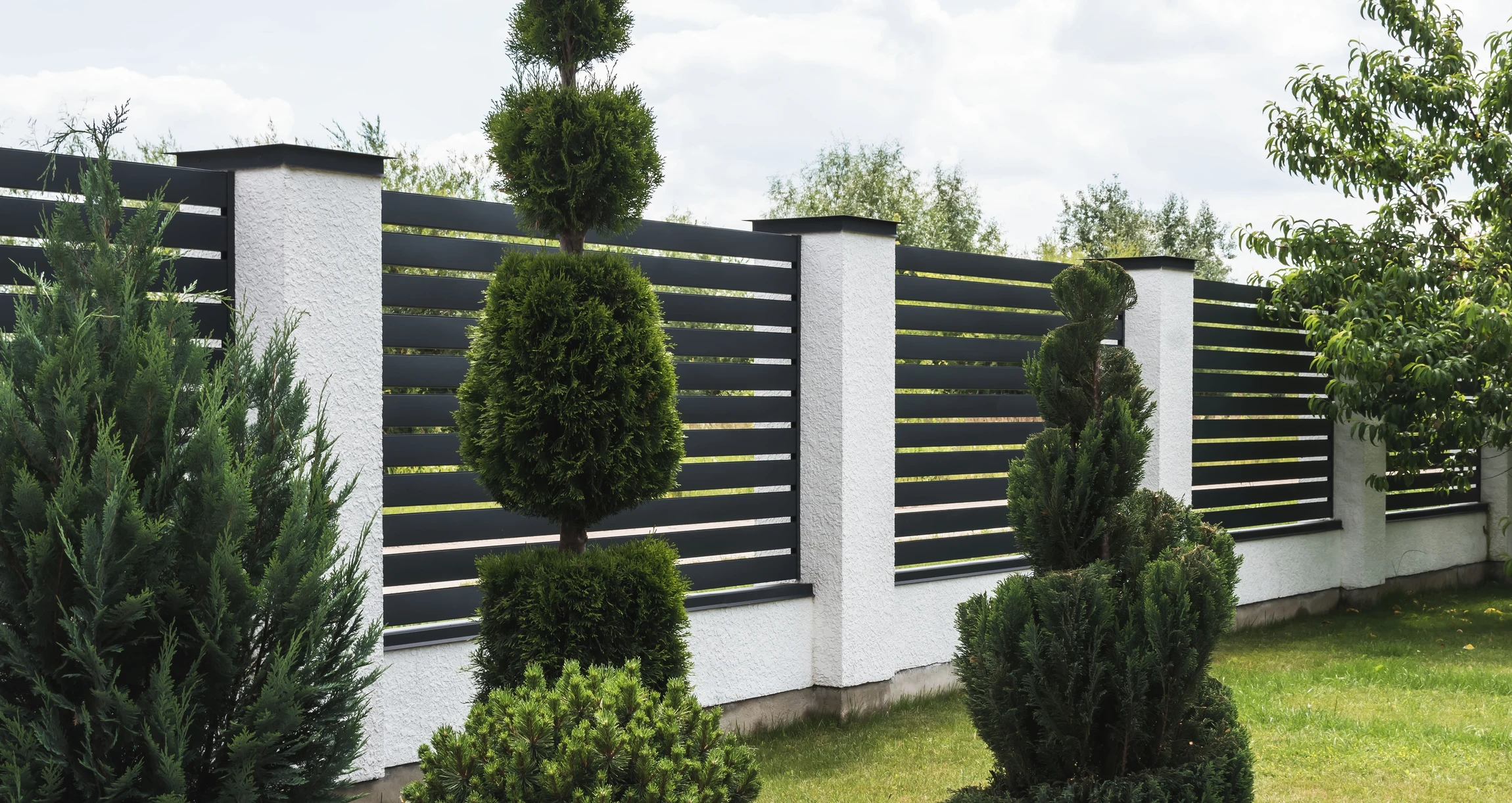 Clôture moderne extérieure avec panneaux horizontaux anthracite et piliers béton blanc