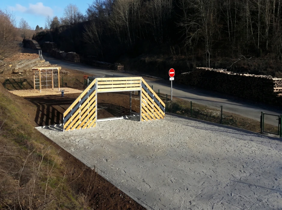 Clôture rigide en panneaux de grillage soudé anthracite (RAL 7016), avec lames brise-vue PVC ondulées horizontales, fixée sur poteaux métalliques encastrés dans un socle béton avec lit de gravier