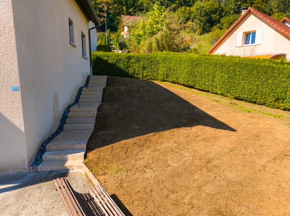 Talus extérieur recouvert d'un géotextile tissé vert de stabilisation, maintenu par des bordures béton