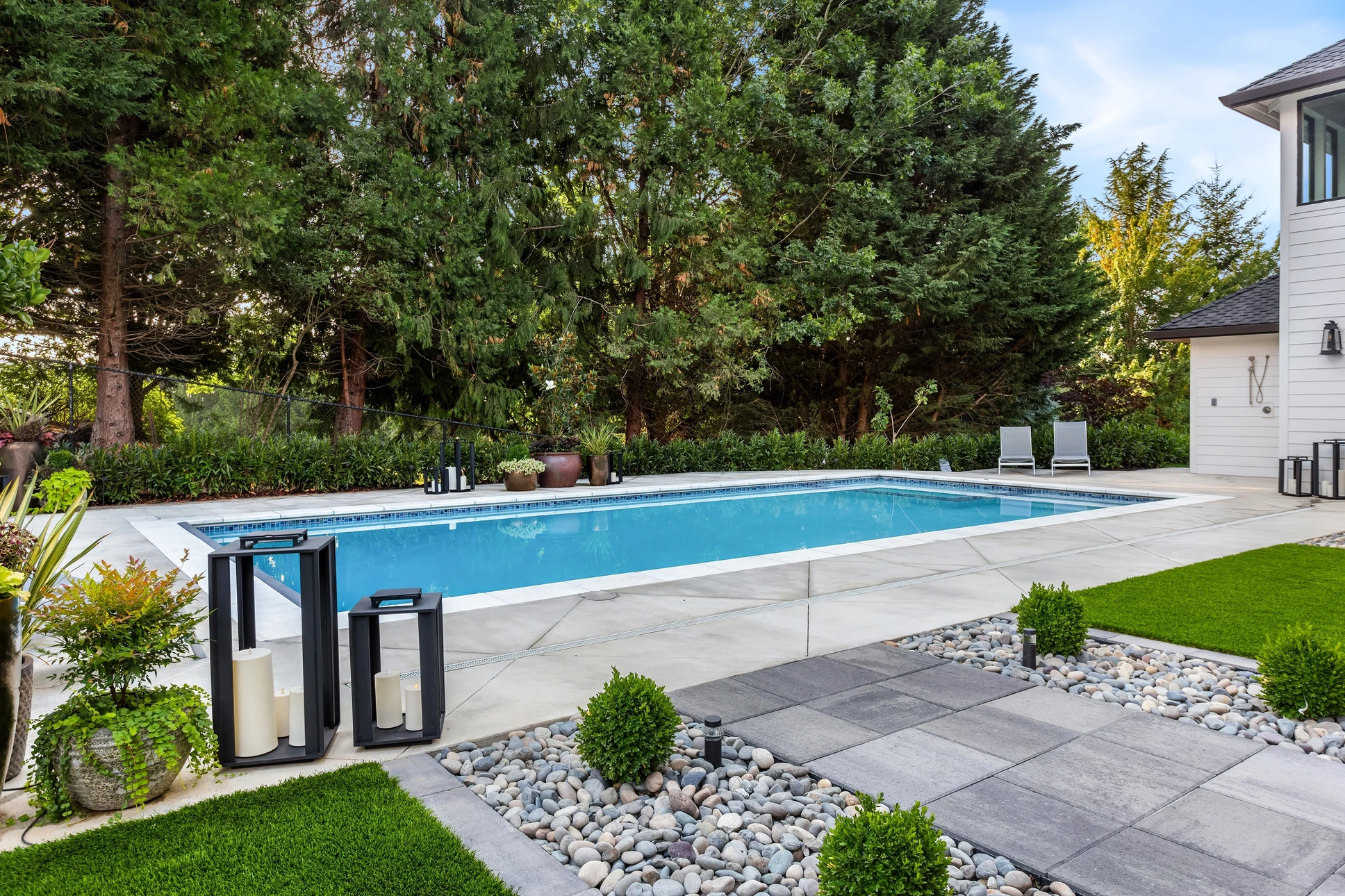 Terrasse extérieure en dalles de pierre naturelle bordant une piscine turquoise
